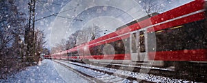 Red train speeding in the snow