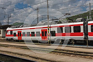 Red train in train station, empty platform, on background Slovakia mountains