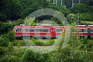 Red train vehicle in greenery