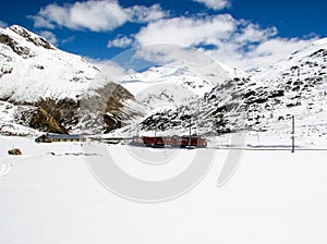 Red train in winter landscape in the Swiss ALps
