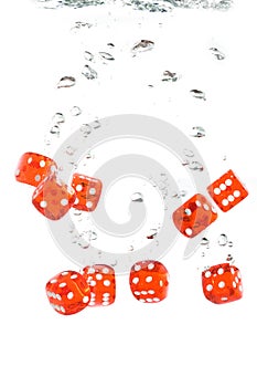 Red transparent dice falling into the water