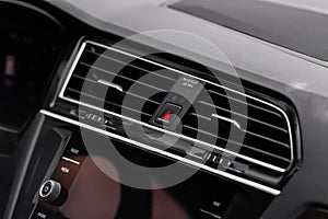 Red triangle hazard light button on car dashboard.