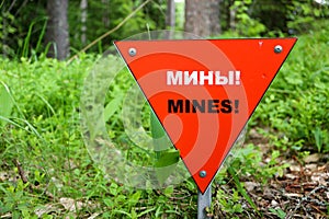 Red triangle mine warning sign in the forest