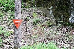 Red triangle mine warning sign in the forest