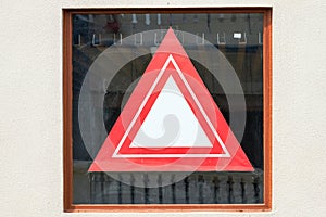 A red triangle prohibition sign taped to the window