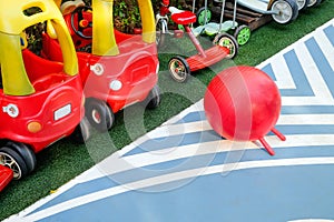 Red tricycles line up beside a track in a children\'s playground area