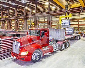 Red truck being loaded in the bay under ceiling lights