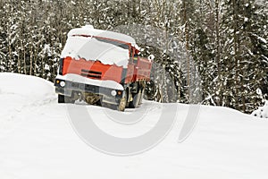 A red truck covered in snow.