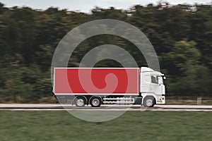 Red truck driving on the countryside asphalt road