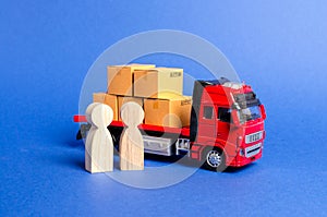 A red truck loaded with boxes near a customer buyer and seller. Business and commerce. Negotiations on supply of goods. Services