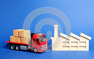 A red truck loaded with boxes stands near the factory. Services transportation of goods products, logistics in the industry