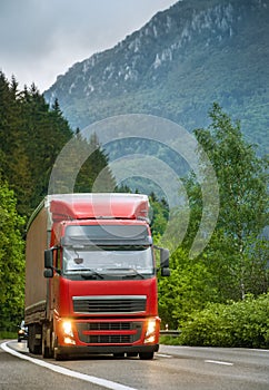 Red truck on mountain highway in the evening