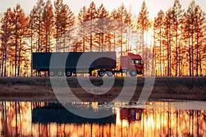 Red truck on a road at sunset