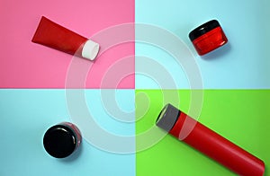 Red tubes for body skin care on a colorful background