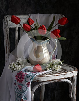 Red tulips bouquet in white vase on vintage cher