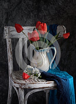 Red tulips bouquet in white vase on vintage cher photo
