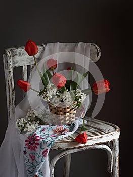 Red tulips bouquet in wooden vase on vintage cher