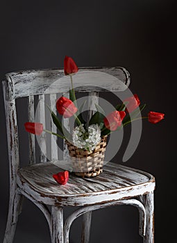 Red tulips bouquet in wooden vase on vintage cher