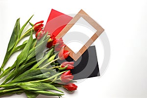 Red tulips with colored envelopes and a blank frame