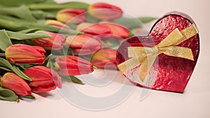 Red tulips with heart gift on white background