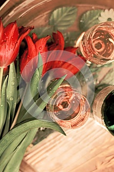 Red tulips in waterdrops with wineglasses photo