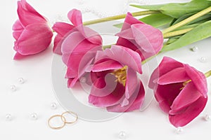Red tulips, wedding rings, perfume and bead