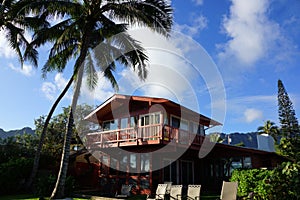 Red Two Story Beach House with tall coconut trees