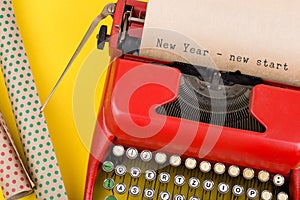 red typewriter with text "New Year - new start" and wrapping paper photo