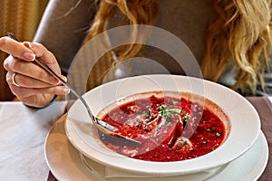 Red Ukranian Beet soup. Girl eating healthy at lunch