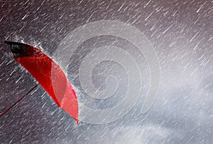 Red umbrella against the storm,sky background and black cloud group and rain, preventing rain and wind hazards,saving planning,