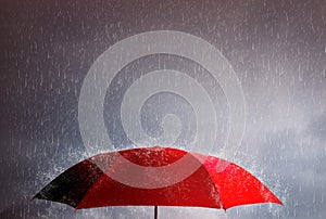 Red umbrella against the storm, sky background and black cloud group and rain, thunderstorm with savings and investment, life and