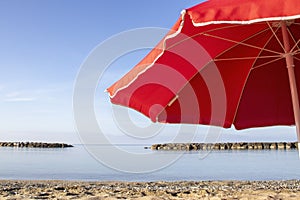 Red Umbrella on the Beach. Beach Umbrella, Summer Background. Vacation and Family Vacation. Umbrella as Protection Against Burns