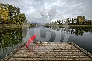 Red umbrella on a dock by the water