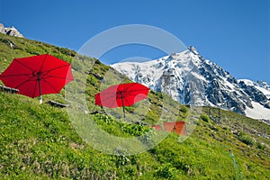 Red umbrellas and lounges in mountain cafe