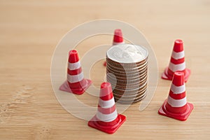 Red under construction cone around stacked coins. Global world economy inflation crisis, repair, fix, revise or reset investment