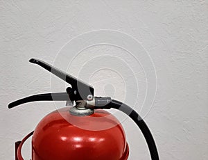 The red upper part of the fire extinguisher on a white background.
