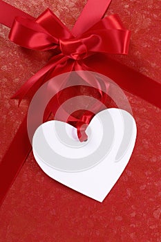 Red valentine gift, white heart shape gift tag or label, copy space, vertical