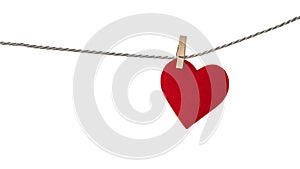 Red valentine heart hanging from a rope fixed by wooden clothespin isolated on white background