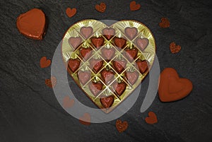 Red Valentine`s Day Chocolate Hearts on a black Stone Background