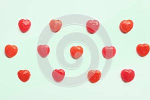 Red Valentine`s day heart candy pattern on green pastel paper color background. Love Concept. colorful hipster style. top view.