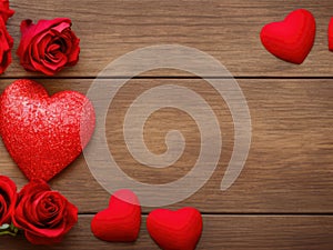 Red valentines day hearts and roses on a wooden table seen from above