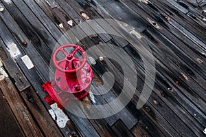 A red valve on the deck of a battleship.