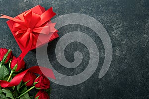 Red velvet or brownie cookies on heart shaped in chocolate icing with red roses and gift box on black background. Dessert idea for