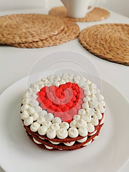 Red velvet cake in the shape of a heart on a white background on the table. Sweet dessert for valentine's day and