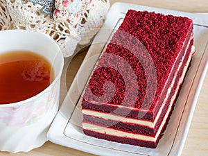 Red velvet cake on wood table and cup of tea