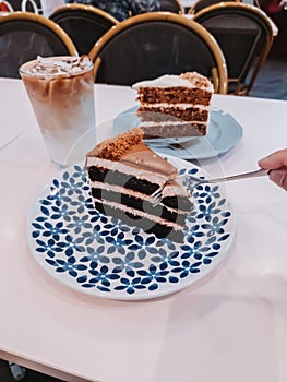 Red velvet and carrot cakes on the table with iced latte for tea time