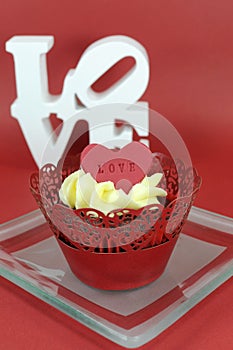 Red velvet cupcake with vanilla frosting and cute red hearts with love message