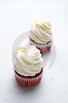 Red velvet cupcakes with cream cheese frosting on light background. Valentine\'s Day concept.
