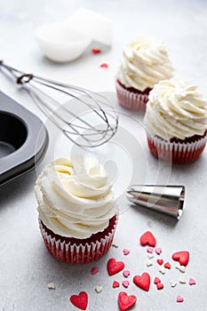 Red velvet cupcakes with cream cheese frosting on light background. Valentine\'s Day concept.