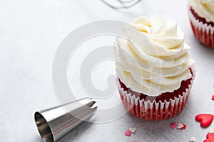 Red velvet cupcakes with cream cheese frosting on light background. Valentine\'s Day concept.